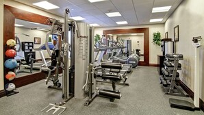 A gym with various exercise equipment, including treadmills, weight machines, and free weights.