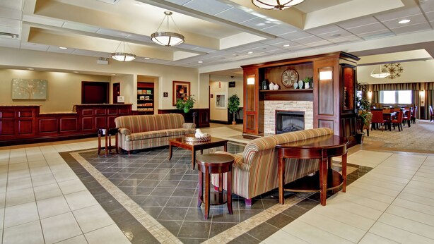 A spacious lobby with a fireplace, sofas, and a reception desk.