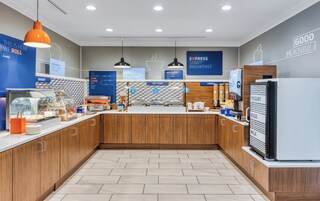 Un moderno comedor con una sección de panadería, opciones de comida caliente y un refrigerador para yogur.