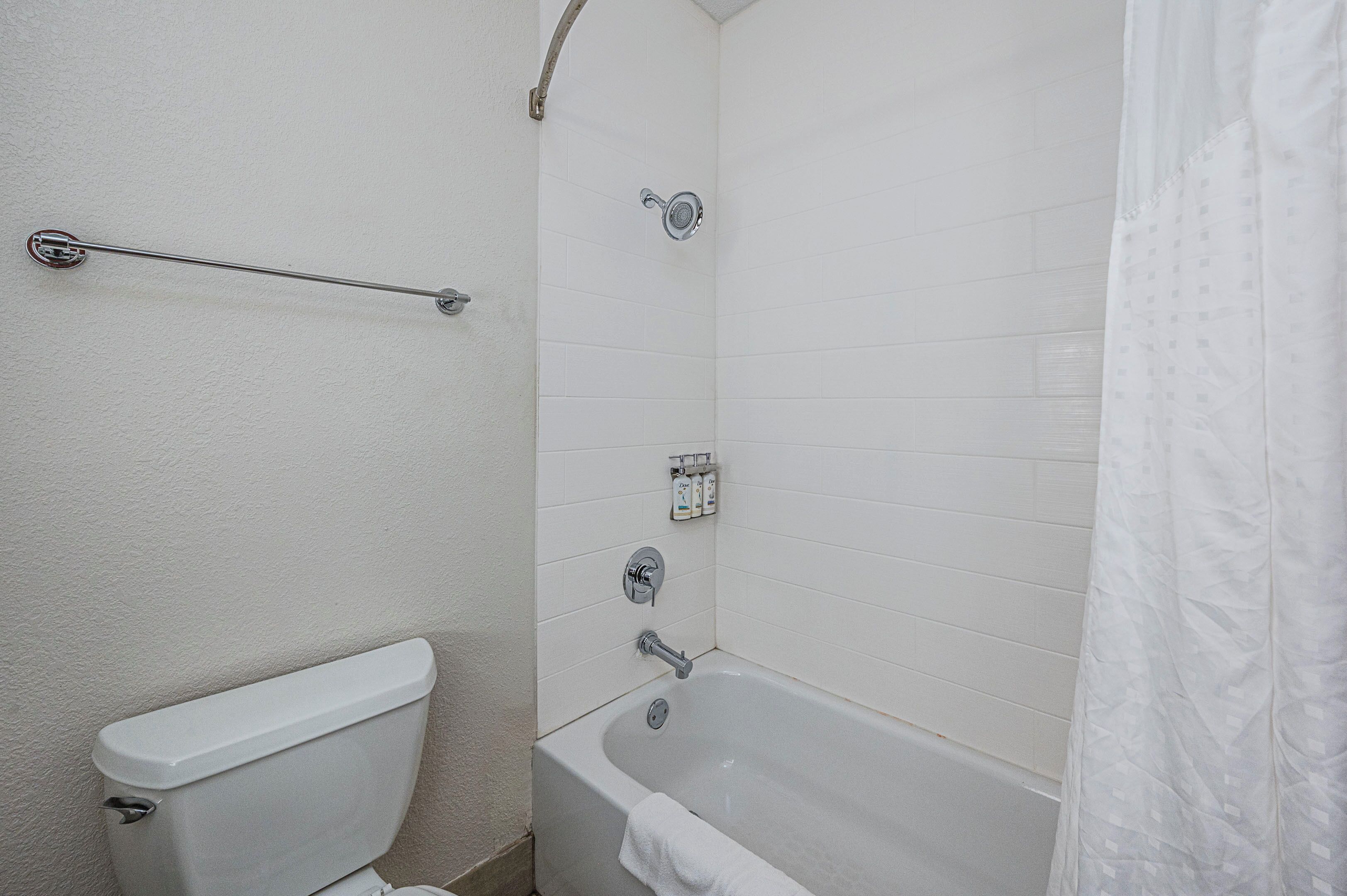 A bathroom with a toilet, a bathtub, and a shower.