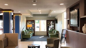 A lobby with seating areas, a reception desk, and a television. - Holiday Inn Express & Suites Franklin KY by IHG (Franklin)