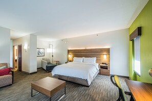 A hotel room with a large bed, a desk, a chair, a sofa, and a bedside table. - Holiday Inn Express & Suites Franklin KY by IHG (Franklin)