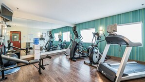 A gym with exercise equipment, a large mirror, and teal walls. - Holiday Inn Express & Suites Franklin KY by IHG (Franklin)