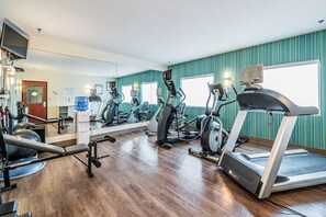 A gym with exercise equipment, a large mirror, and teal walls. - Holiday Inn Express & Suites Franklin KY by IHG (Franklin)