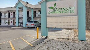 A motel with a sign reading "Savannah Garden Hotel."