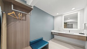 Ein modernes Badezimmer mit einer Bank, einem Spiegel und einem Handtuchhalter.