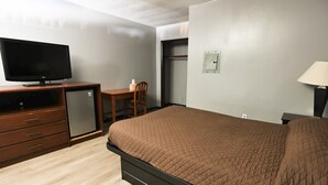 A hotel room with a bed, a dresser, a television, a desk, and a chair. - Budget Inn and Suites (Mount Ephraim)