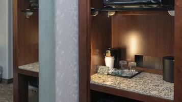 A kitchenette with a microwave, a coffee maker, and a small refrigerator.