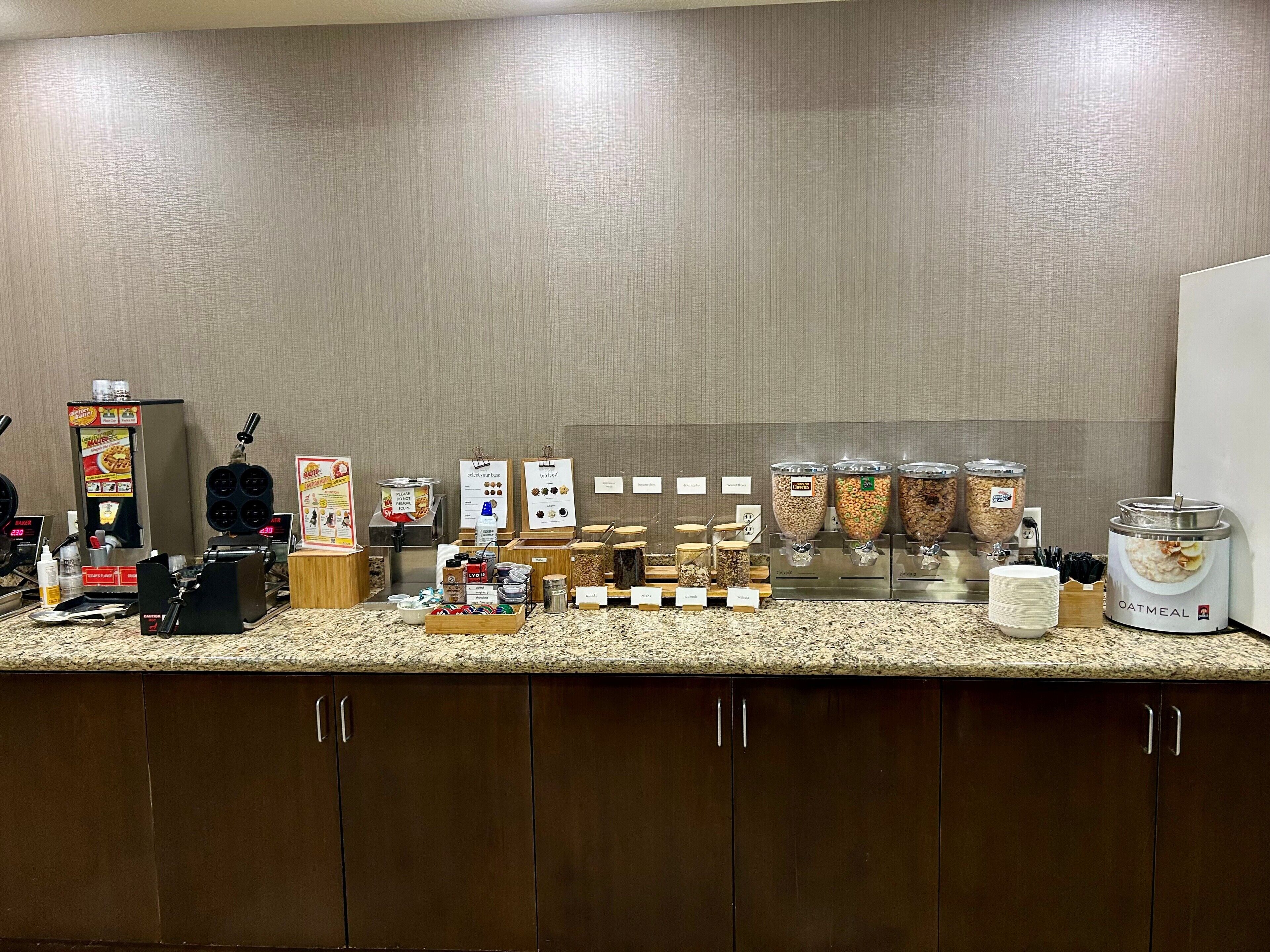 Una barra de desayuno con diversas opciones de comida y una máquina de café.