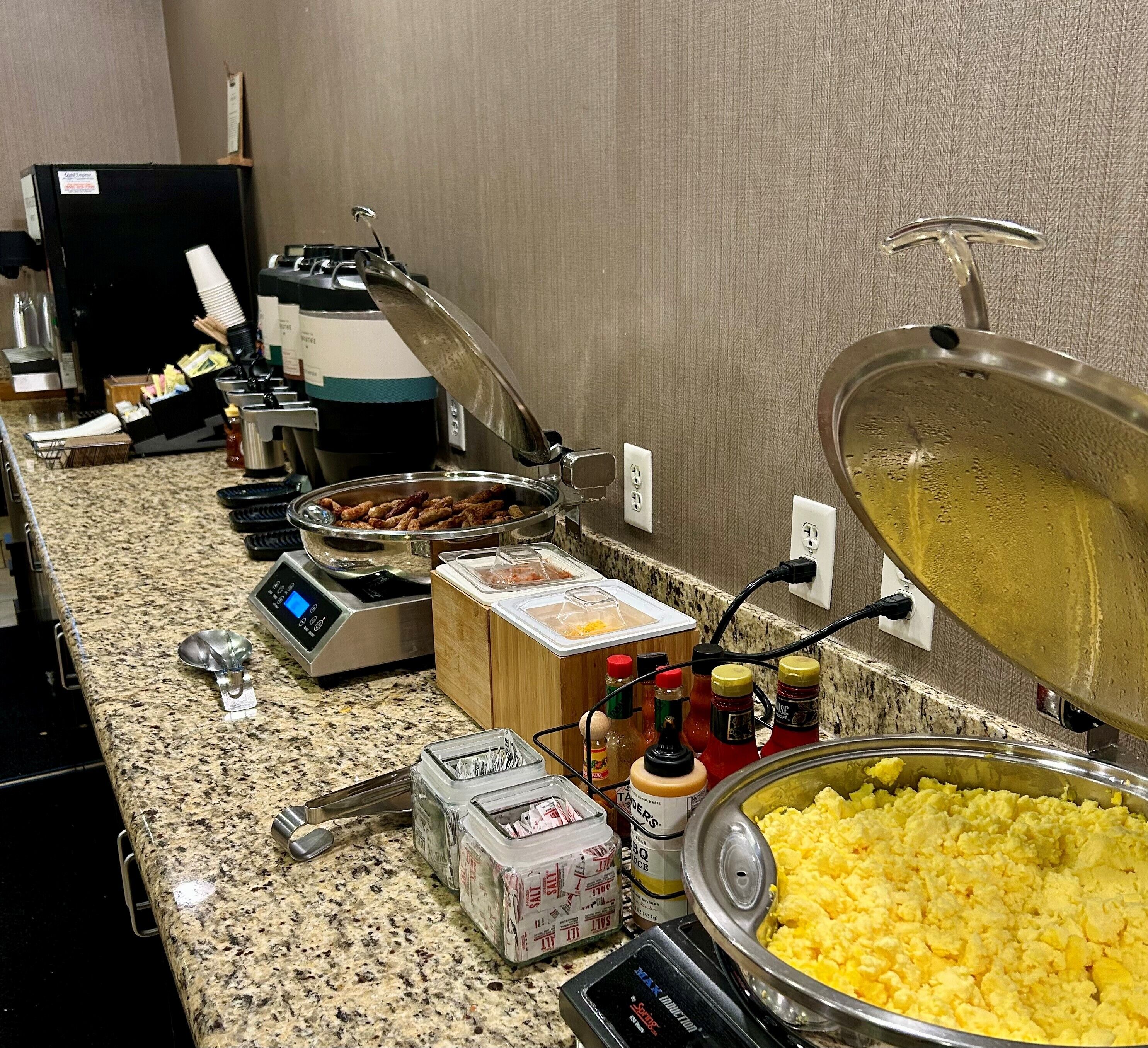 A buffet setup with various food items and condiments.