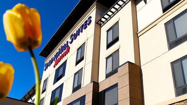 A hotel with a modern facade, large windows, and a sign indicating it is a Marriott hotel.