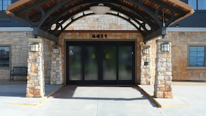 Un bâtiment de la chaîne Staybridge Suites, doté d’une façade en pierre, de nombreuses fenêtres et d’une entrée abritée.