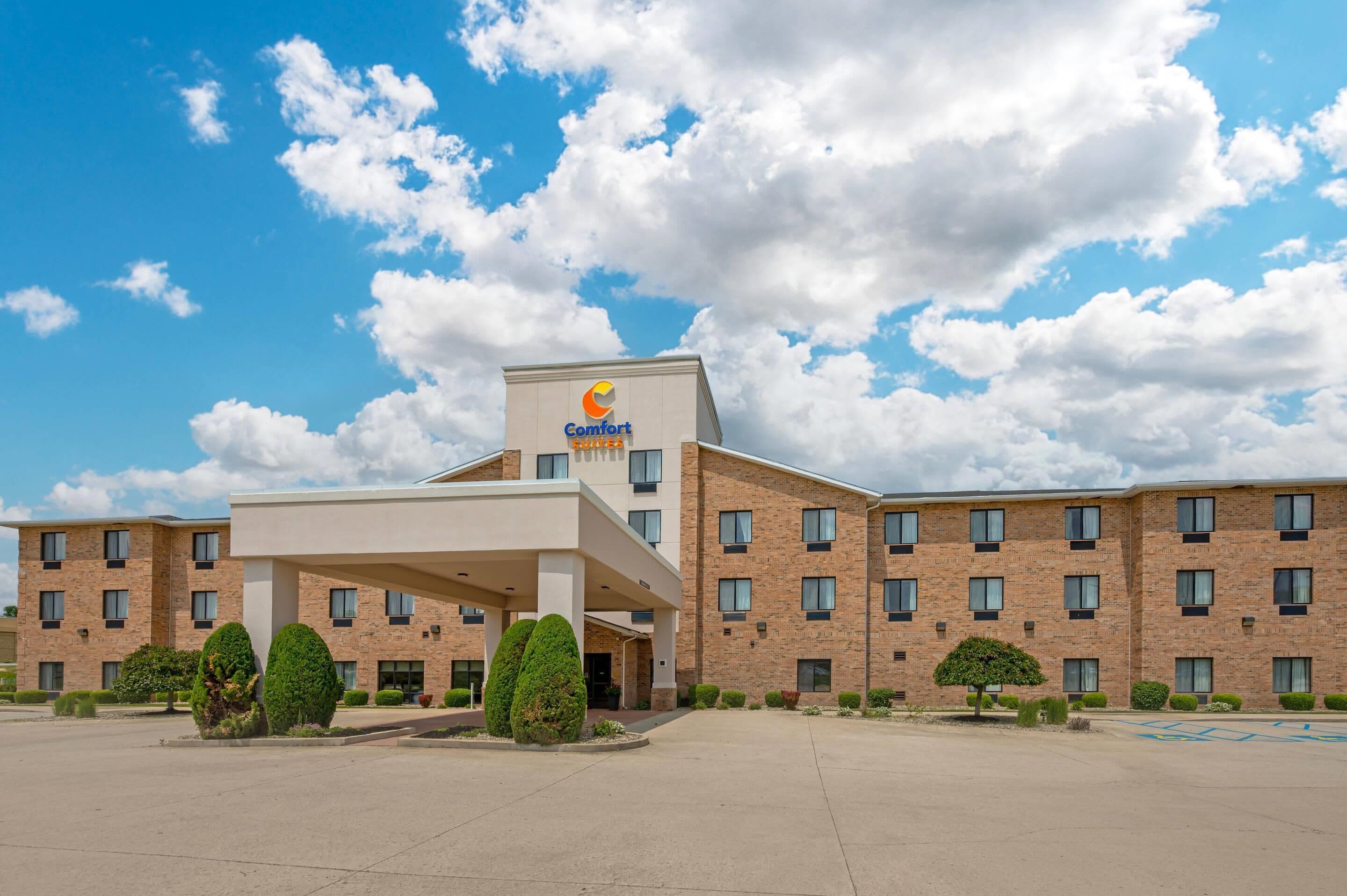 A Comfort Suites hotel with a brick facade, multiple windows, and a covered entrance area.