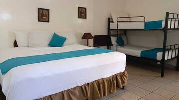 A hotel room with a single bed, a bunk bed, a nightstand, and two wall-mounted pictures.