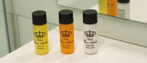 Three bottles of Hotel Plaza Sevilla products on a white counter.