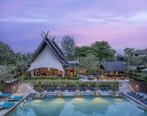 A resort with a pool, lounge chairs, and a building with a unique roof design. - Anantara Mai Khao Phuket Villas (Mai Khao)