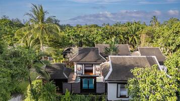 Resort com vários edifícios cercado por vegetação exuberante e um corpo de água.