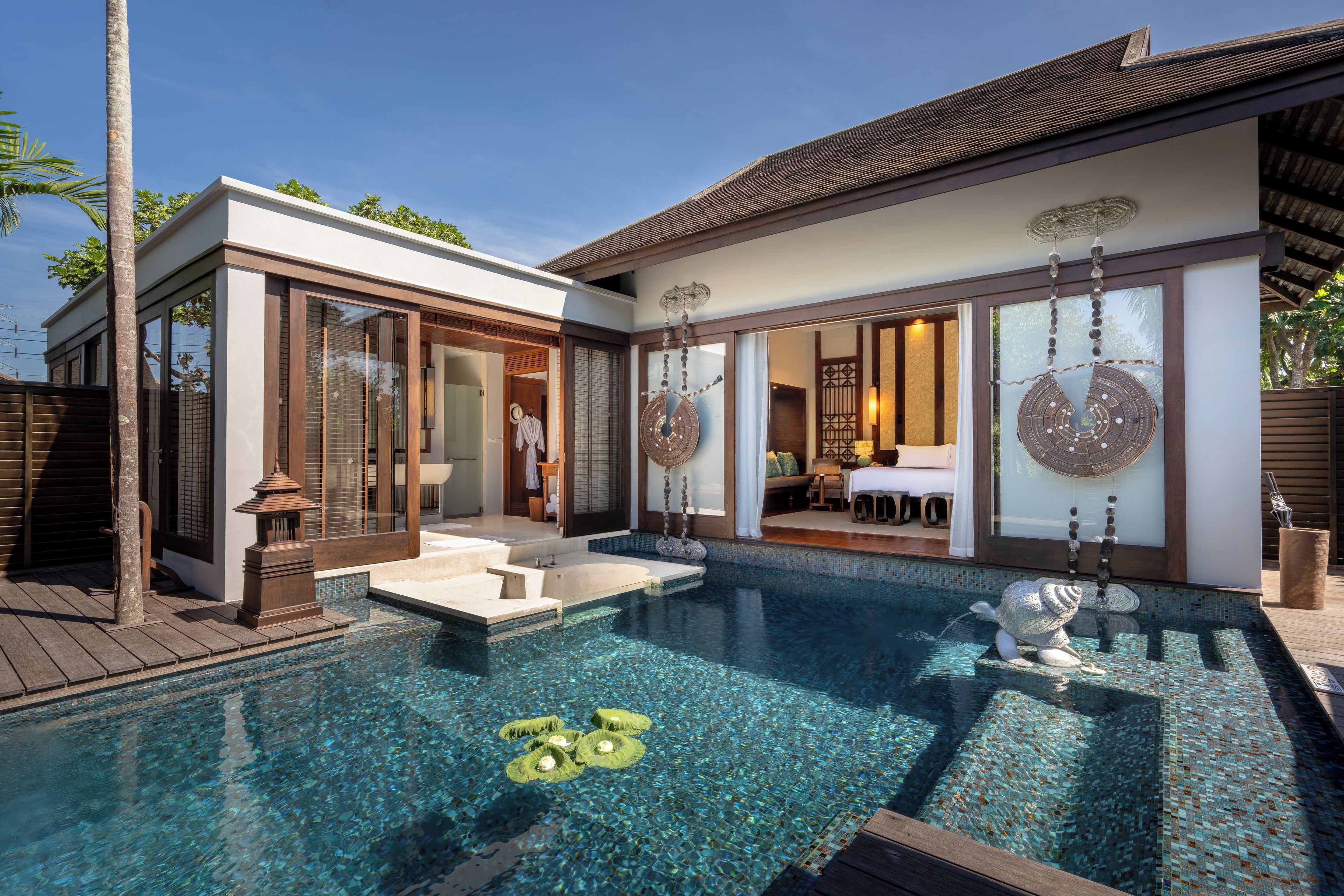 A modern house with a swimming pool, a separate entrance, and a dining area.