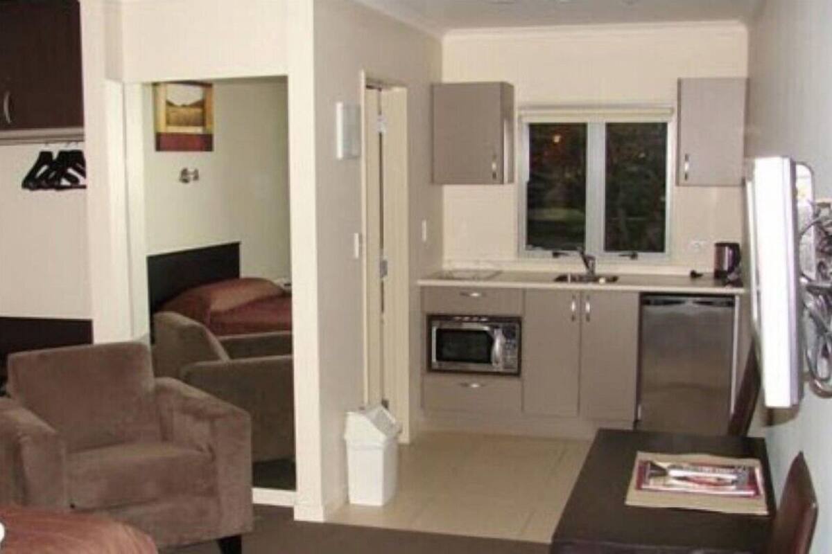 A compact living space with a kitchenette, a dining area, and a bedroom.