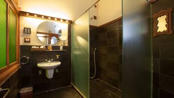 Une salle de bain avec un lavabo, un miroir et une douche.