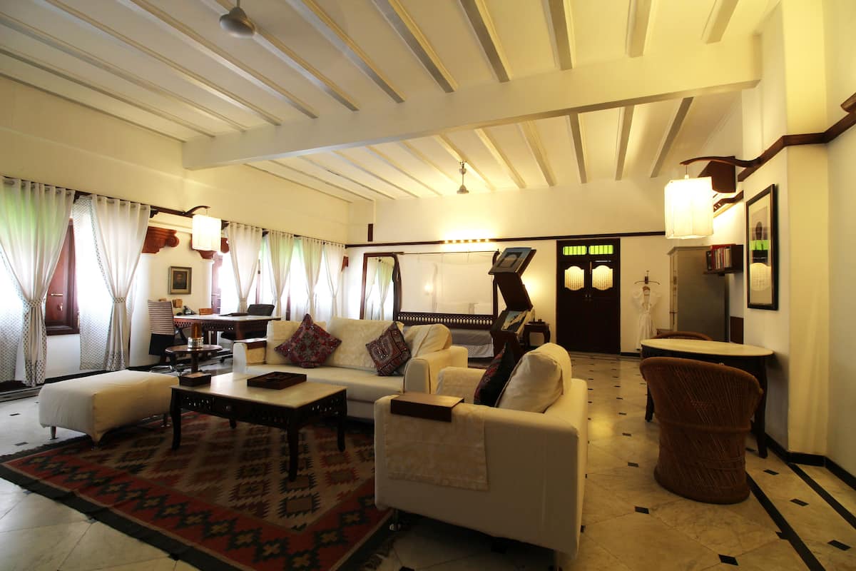 A spacious living room with a sofa set, a coffee table, and a patterned rug.