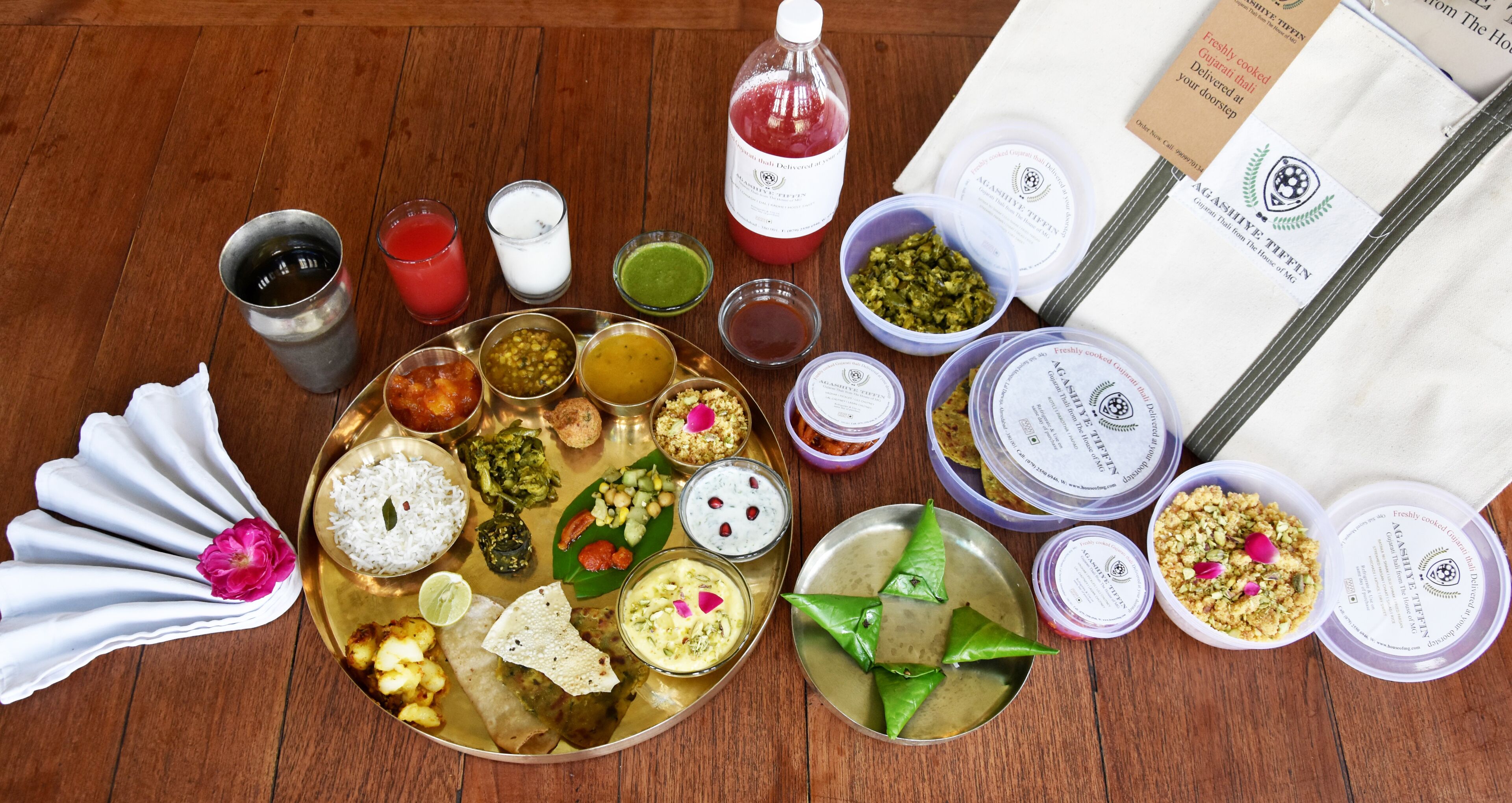 Una bandeja con diversos platos y aderezos, junto con un botellín de jugo, un vaso de leche y una servilleta.