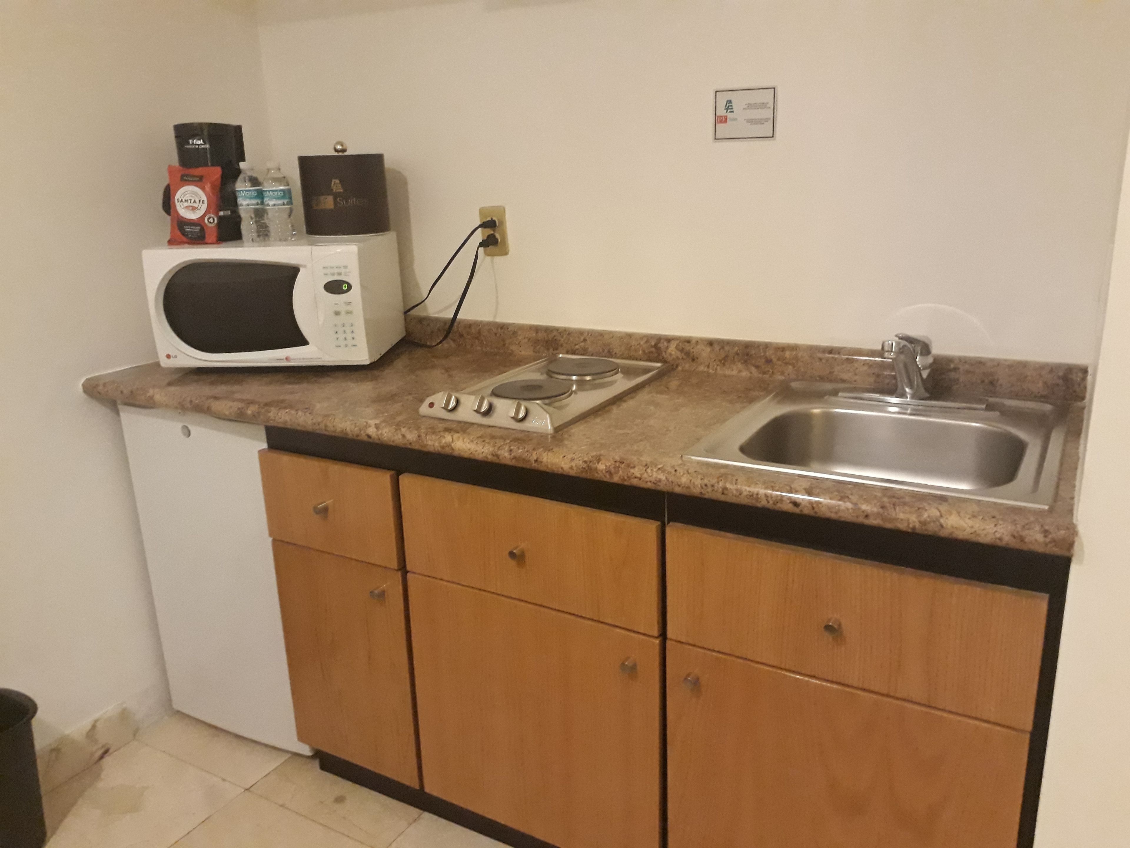 Uma cozinha compacta com micro-ondas, fogão e pia.