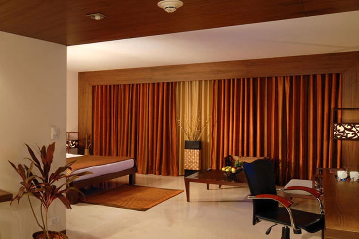 A modern hotel room with a large mirror, a bed, a desk, and a chair.