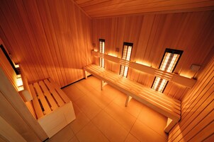 Una sala de sauna con paredes y bancos de madera.