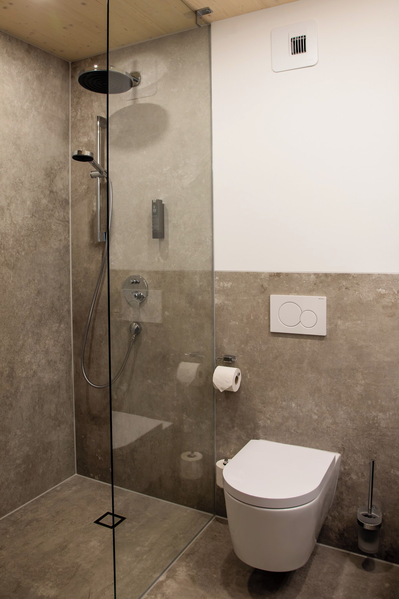 Un baño moderno con ducha de vidrio, inodoro y toallero.