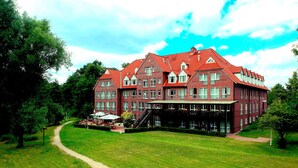 A large, red brick building with multiple windows and a central staircase. - Park Hotel Fasanerie Neustrelitz (Neustrelitz)