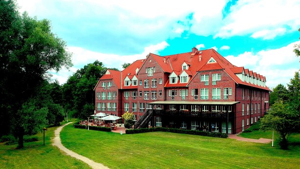 A large, red brick building with multiple windows and a central staircase. - Park Hotel Fasanerie Neustrelitz (Neustrelitz)