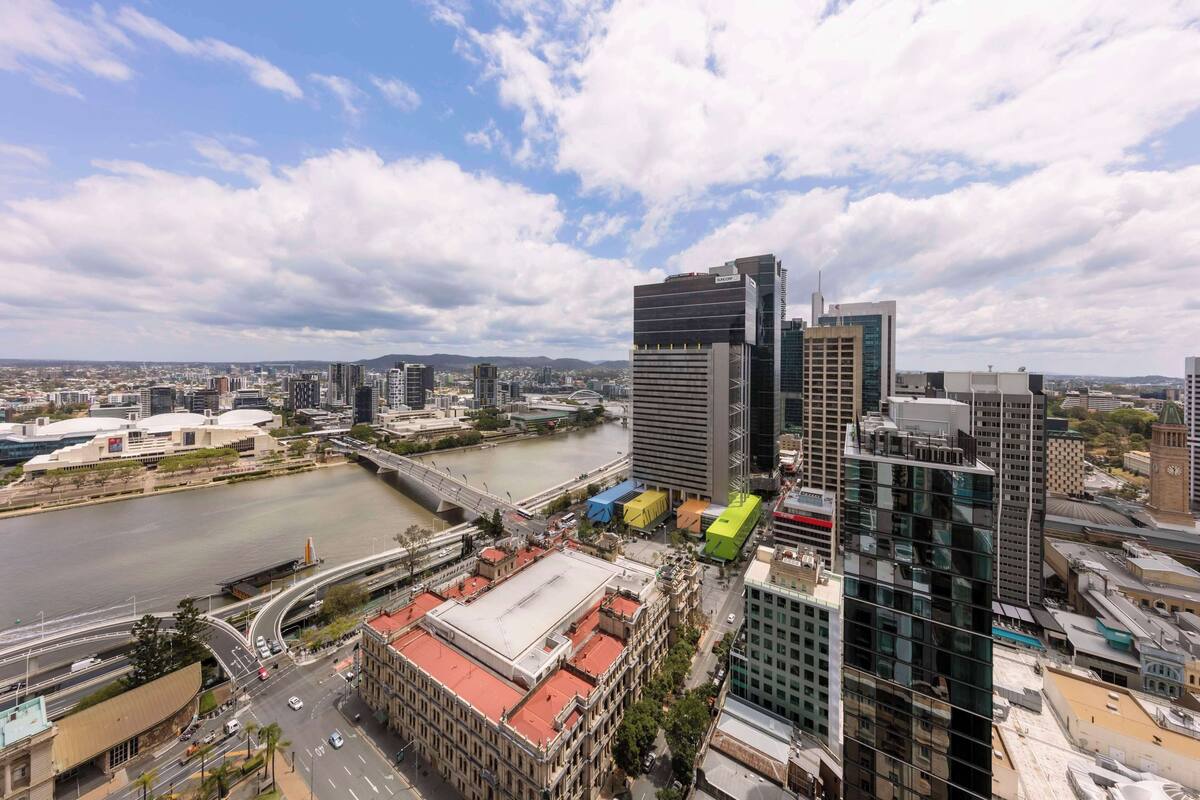 Une vue urbaine avec des bâtiments modernes, une rivière et un pont.