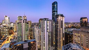 A high-rise urban skyline with modern architecture, including a distinctive curved building and several high-rise buildings with illuminated windows. - Oaks Brisbane Casino Tower Suites (Brisbane)