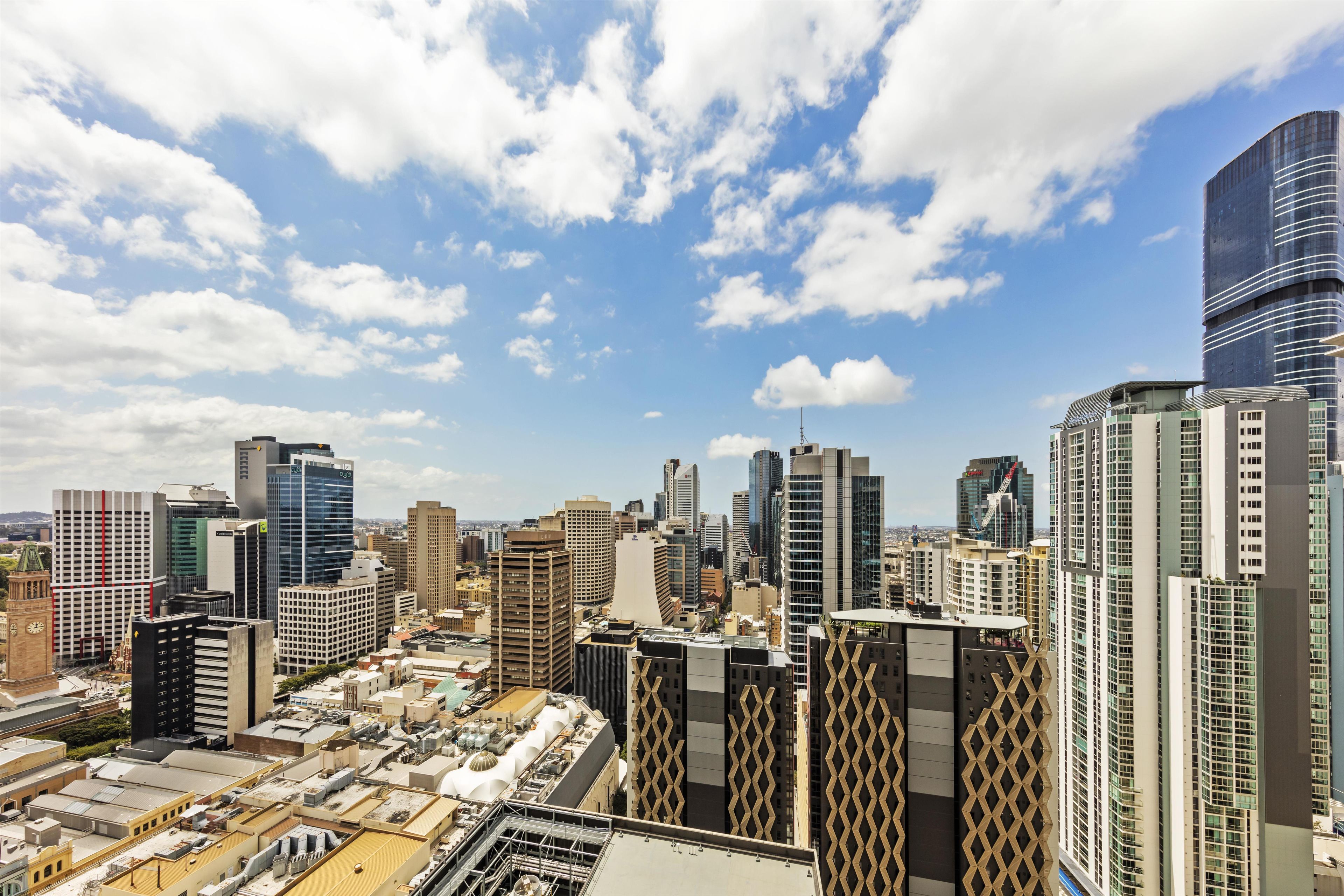 A cityscape with high-rise buildings, including a distinctive building with a lattice facade.