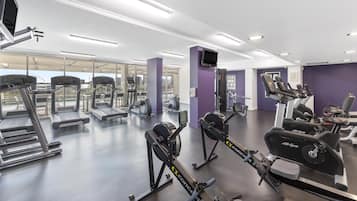 Un gimnasio con equipos de ejercicio variados, incluyendo cintas de correr y bicicletas estáticas.