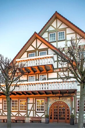 Un hotel europeo tradicional con una entrada destacada, varias ventanas y un balcón.
