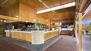 A modern bar area with wooden accents, a central island, and a television screen. - Noosa North Shore Retreat (Noosa North Shore)