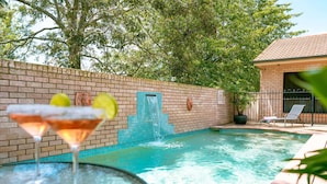 A swimming pool with a brick wall, a blue door, and a lounge chair. - Best Western Tuscany On Tor Motor Inn (Newtown)