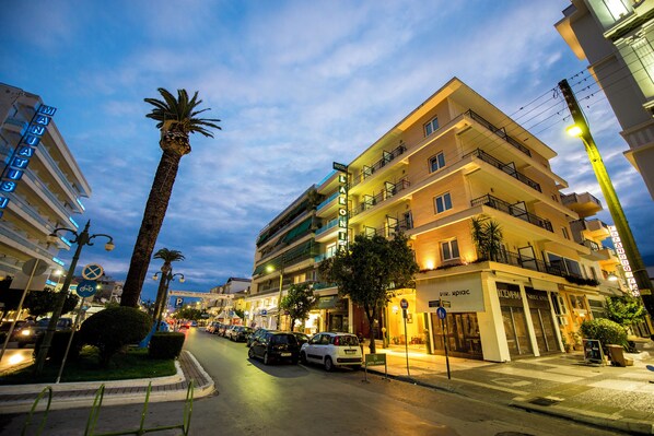 Un hotel con varios pisos, balcones y un cartel que indica que es un hotel.