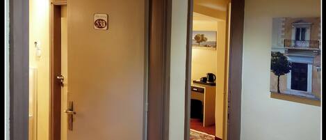A hallway with a door labeled "533" leading to a room with a window and a painting of a building.