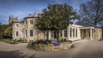 A historic stone building with a reception area and a car park.