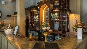 A bar area with a polished granite countertop, a variety of liquor bottles, and a selection of beers from brands like Guinness and Amstel. - Washingborough Hall Hotel (Lincoln)