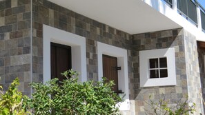 Un edificio con fachada de piedra, dos puertas de madera y una ventana pequeña.