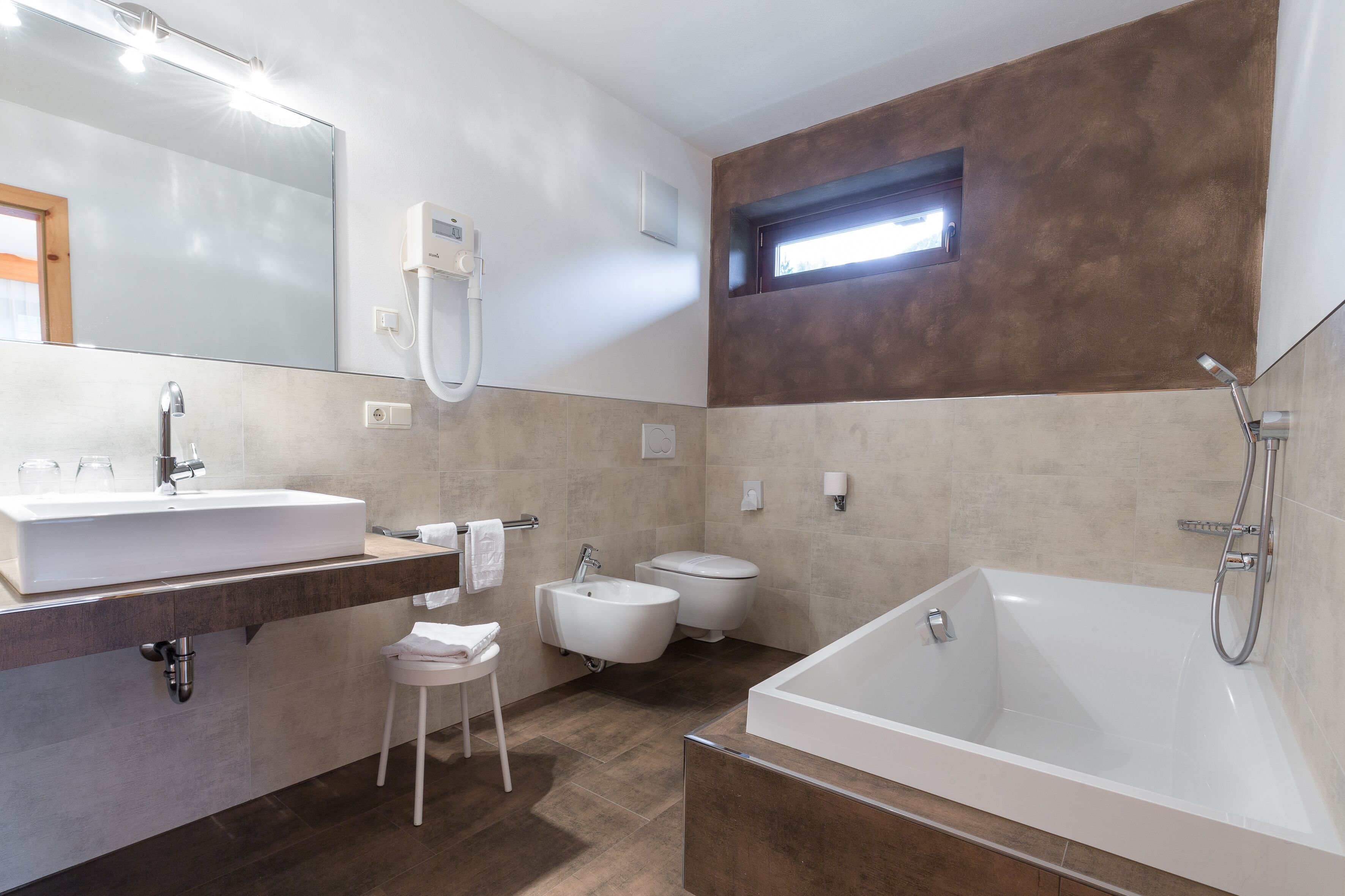 Ein modernes Badezimmer mit einer großen Badewanne, einem Waschbecken und einem Bidet.