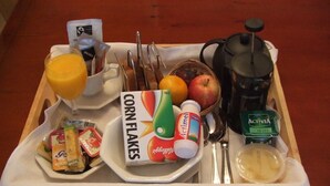 A breakfast tray with corn flakes, orange juice, a bottle of Actimel, a thermos, a fruit basket, and a small container of yogurt. - 31 Queens Road (Winchester)