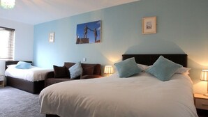 A bedroom with two beds, a nightstand, a lamp, and a wall-mounted picture. - Abbey Bed and Breakfast (Londonderry)