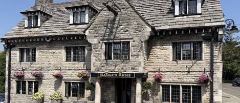 A stone building with a sign reading 'BANKES ARMS' and a pub entrance.