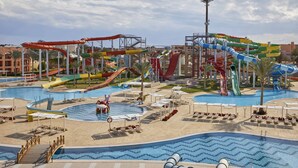 A water park with multiple slides and pools, surrounded by palm trees and lounge areas.