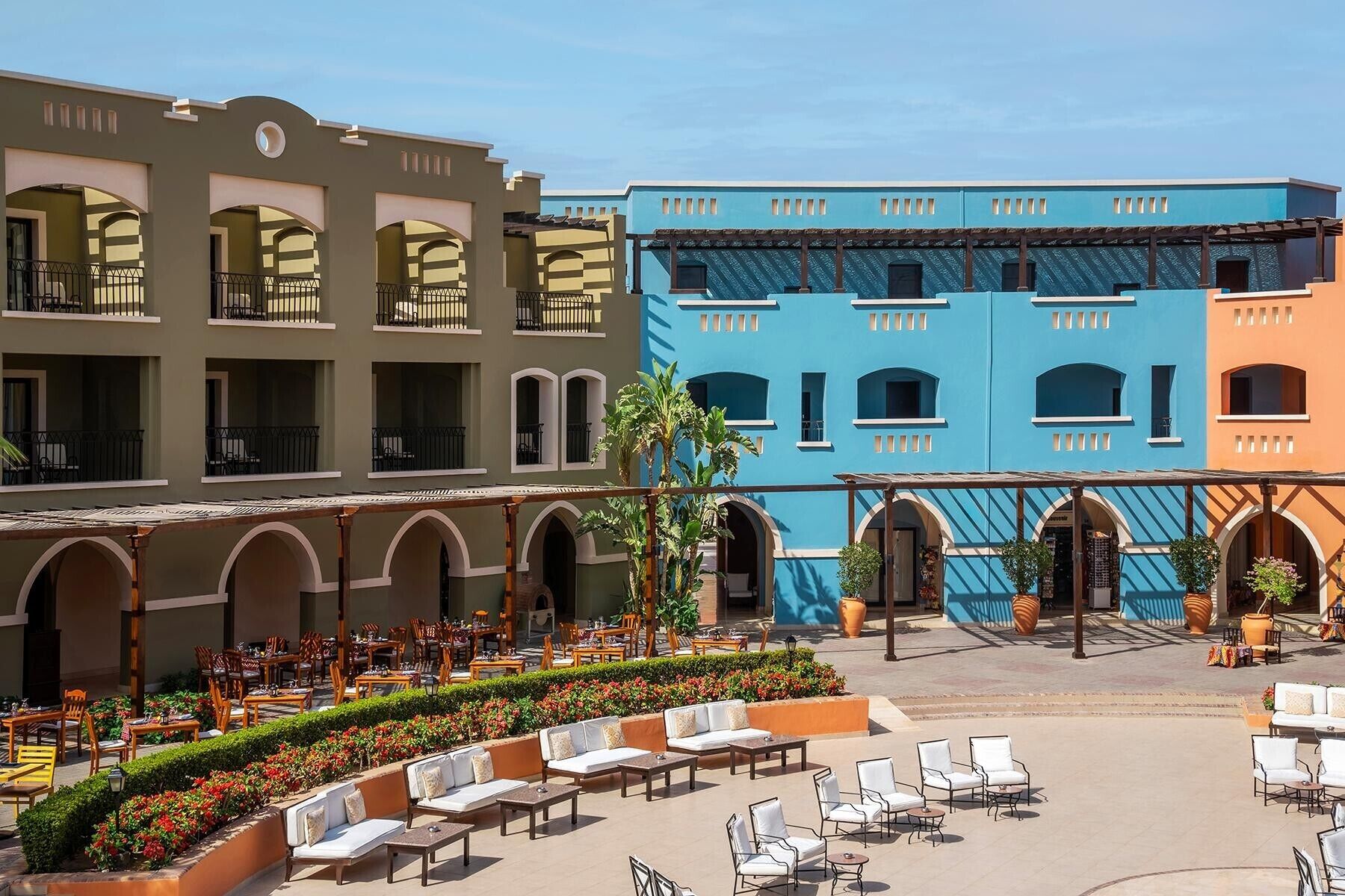 A courtyard with outdoor seating and a building with multiple balconies.